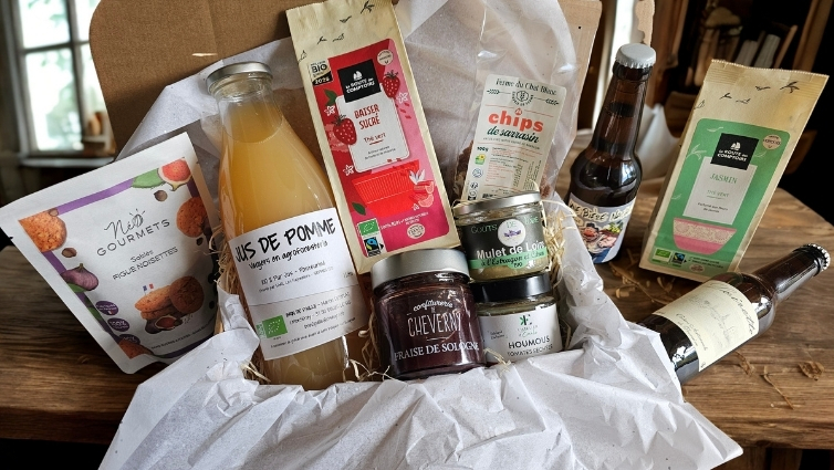 Coffret gourmand ouvert garni de produits bio de Touraine sur table en bois