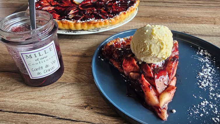 Part de tarte vigneronne aux pommes servie pour le dessert, accompagnée d’une boule de glace