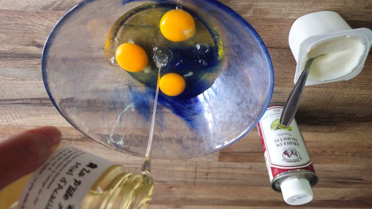 Préparation pâte du gâteau: ajout d'un filet de miel d'acacia dans le saladier.
