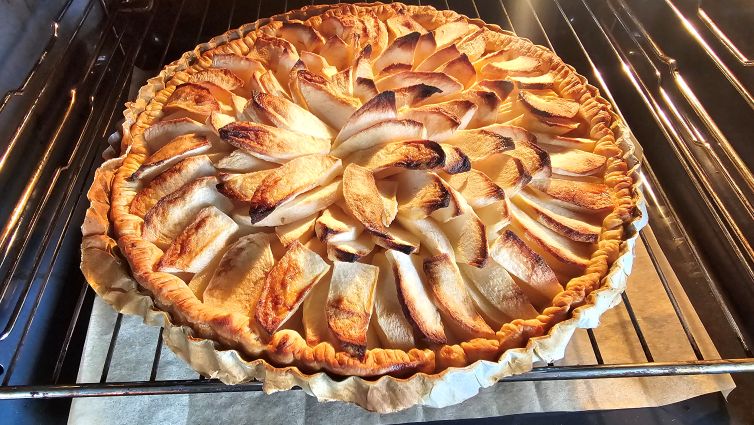 Dressage en rosace des quartiers de pommes Gala sur la pâte avant la cuisson au four